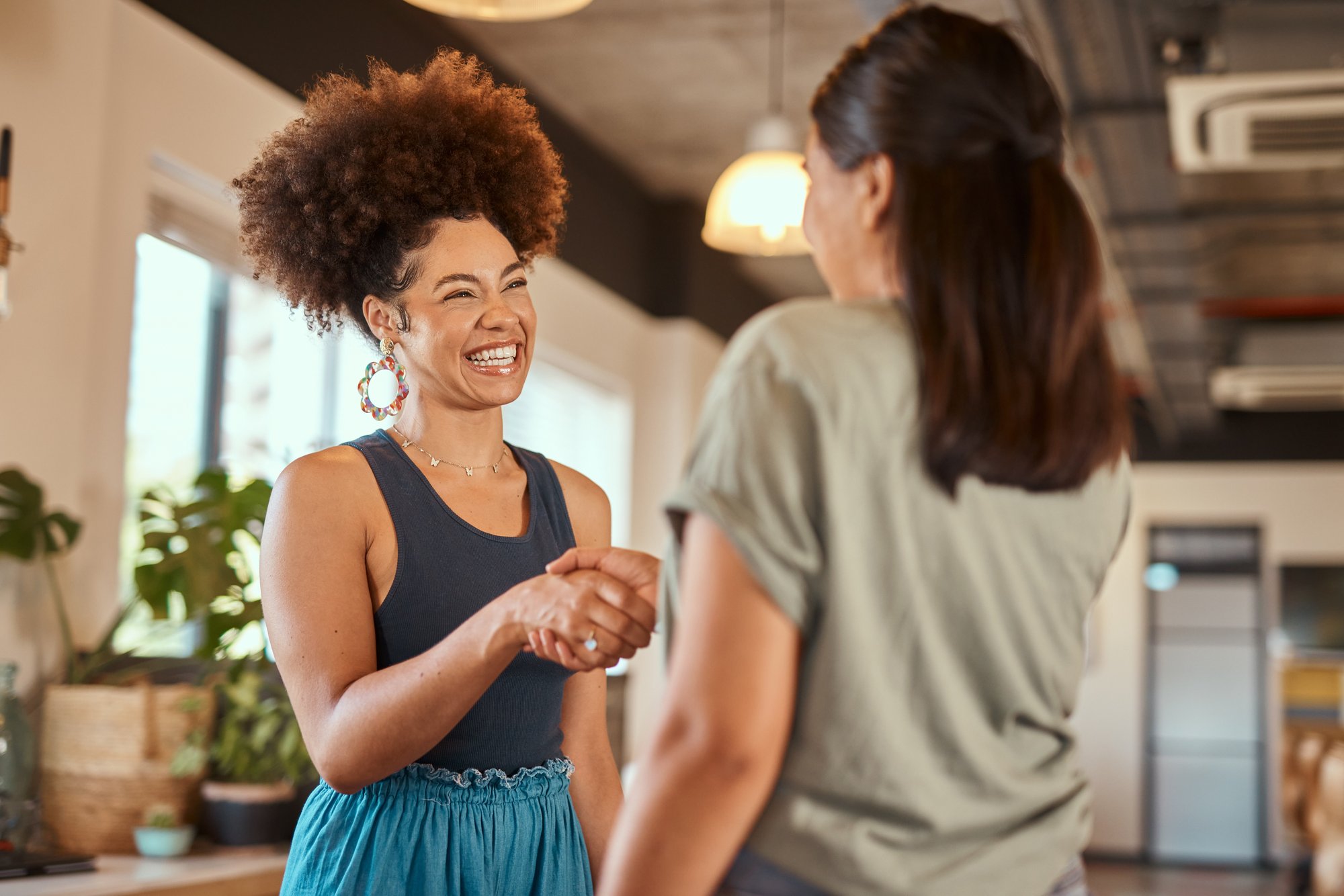 Two happy women shaking hands