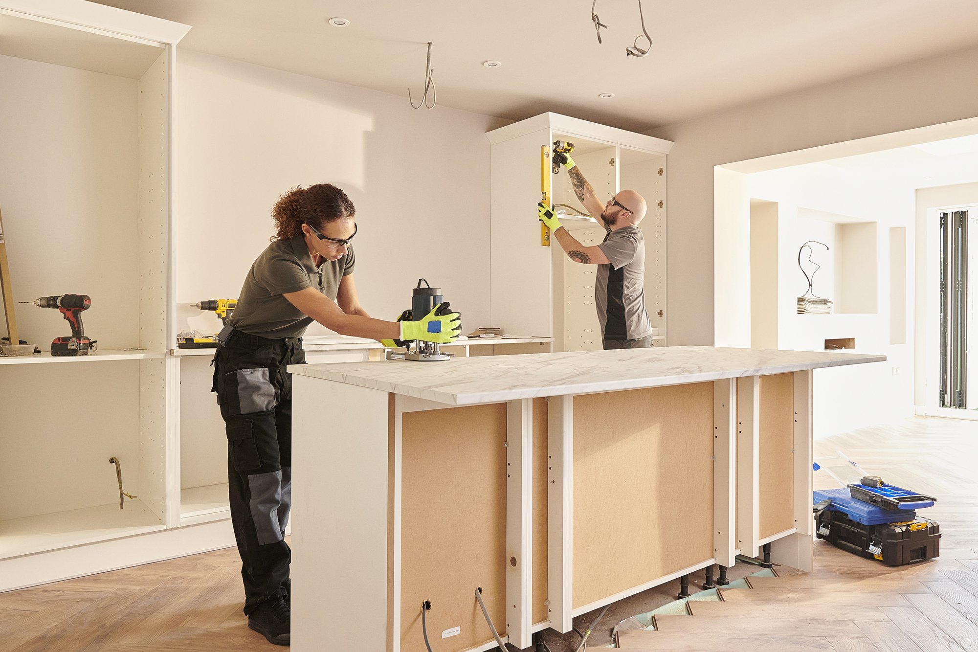 Two people renovating a house using rented electrical tools